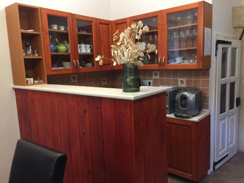 a kitchen with a counter with a vase of flowers at Kikerics vendégház in Villány