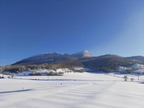 a snow covered field with a mountain in the background at Andamur San Román in San Román