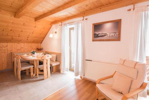 a living room with a table and a chair at Ferienwohnungen Schwalbennest in Mauterndorf