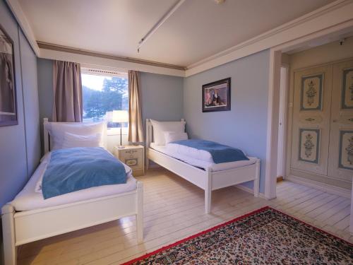 a bedroom with two beds and a window at Strand Hotel Fevik - by Classic Norway Hotels in Fevik