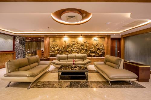 a living room with two couches and a table at Grand Palace Hotel & Resort Sylhet in Sylhet