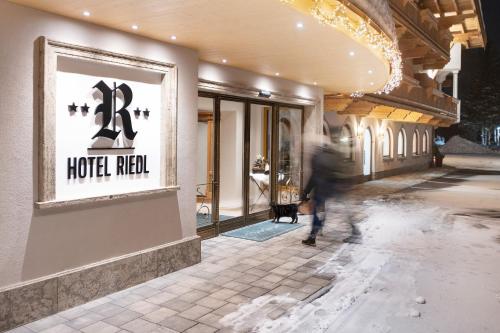 a person walking in front of a store at Hotel Riedl in Kössen
