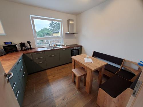 a kitchen with a table and a sink and a table and chair at Ferienwohnungen Im Grund 22, 22a, 22c Birkenstein in Hoppegarten