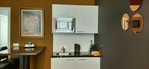 a kitchen with a sink and a microwave at Hotel Zilt in Vlissingen