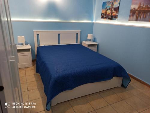 a blue bedroom with a bed with a blue blanket at Il Piccolo Cortile in Catania