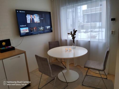 アークレイリにあるCentrum Apartmentの白いテーブル(椅子付)、壁掛けテレビ
