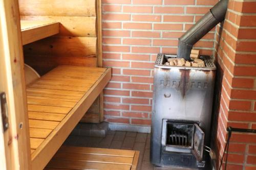 a small room with a stove and a brick wall at Aronsalmen Lomamökit in Nurmes