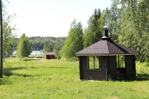a small building in the middle of a field at Aronsalmen Lomamökit in Nurmes