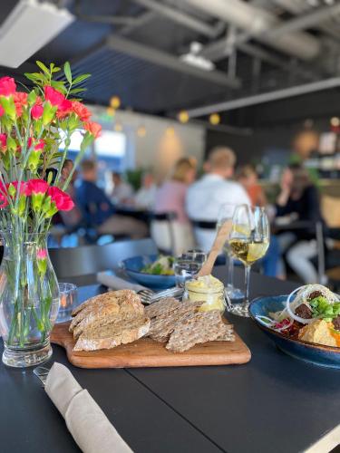 a table with a plate of food and a glass of wine at First Hotel Kokoloko in Visby