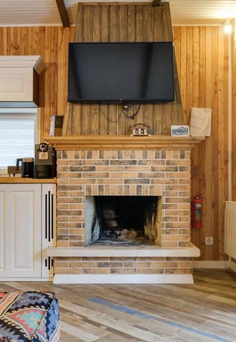a fireplace with a flat screen tv on top of it at Клуб Яремчанський Шале in Yaremche