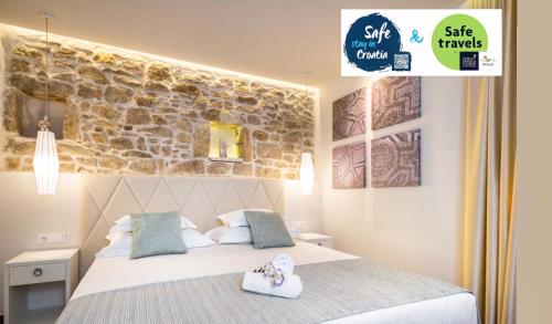 a bedroom with a bed and a stone wall at Balatura The Fine Bed&Breakfast Split in Split