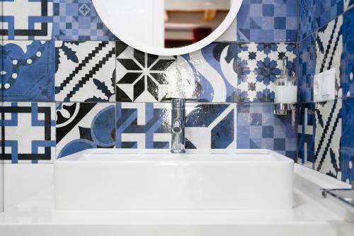 a bathroom with a sink and a mirror at Housingleón - Five Rooms in León