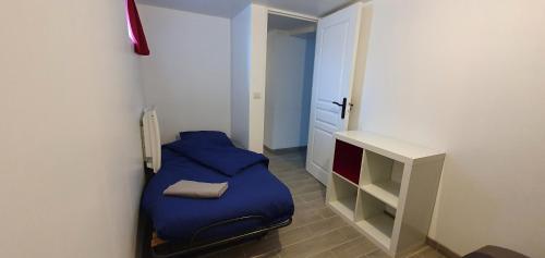 ein kleines Schlafzimmer mit einem blauen Bett in einem Zimmer in der Unterkunft Bald'Home in Saint-Galmier