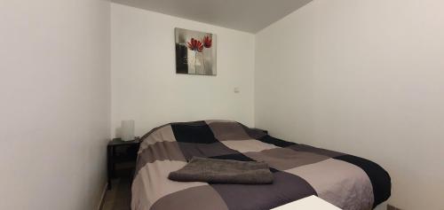 - une chambre dotée d'un lit avec une photo sur le mur dans l'établissement Bald'Home, à Saint-Galmier