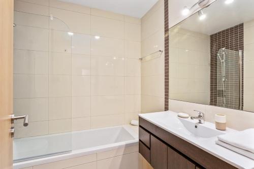 een badkamer met een wit bad, een wastafel en een bad tubermott bij Vale San Antonio Apartments in Almancil