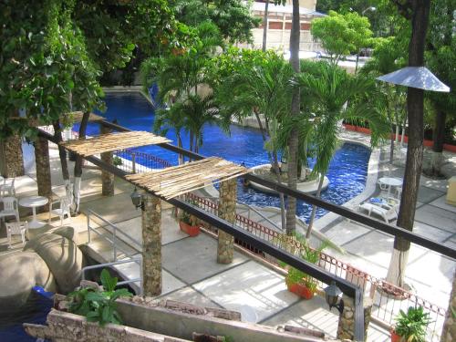 an overhead view of a pool with trees and benches at Hotel Club del Sol Acapulco by NG Hoteles in Acapulco