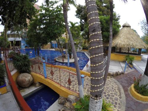 a resort with a swimming pool and palm trees at Hotel Club del Sol Acapulco by NG Hoteles in Acapulco