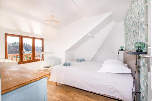 biała sypialnia z łóżkiem i oknem w obiekcie Gite de la Baie des anges w mieście Saint-Valéry-sur-Somme