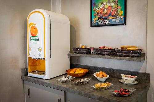 a counter with a refrigerator and some bowls of food at Hotel de la Gare in Châteauroux