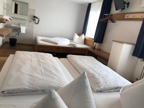 two white beds in a room with a sink at Landgasthof Kreuz in Konstanz