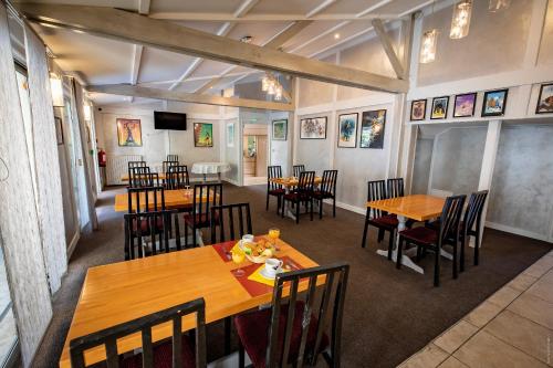 a dining room with wooden tables and chairs at Hotel de la Gare in Châteauroux