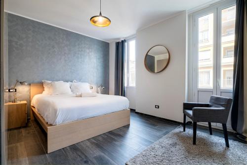 une chambre avec un lit, une chaise et un miroir dans l'établissement Garibaldi Acropolis, emplacement idéal, parking, à Nice