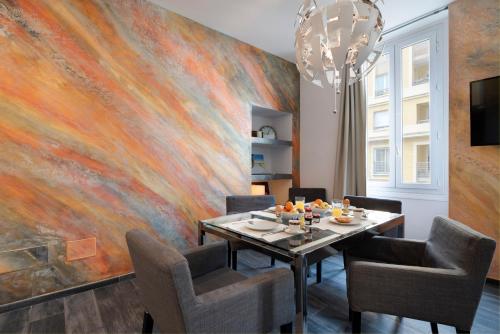 une salle à manger avec un grand tableau mural dans l'établissement Garibaldi Acropolis, emplacement idéal, parking, à Nice