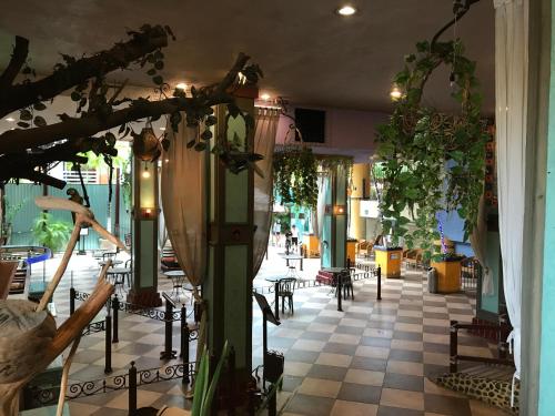 a lobby with tables and chairs and plants at Hotel Club del Sol Acapulco by NG Hoteles in Acapulco