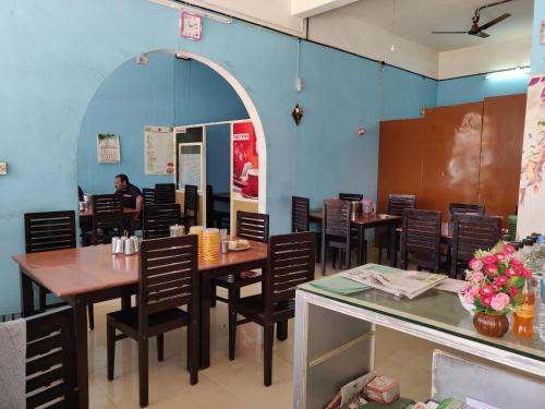 jadalnia ze stołami i krzesłami oraz osoba w lustrze w obiekcie M3 Homes w mieście Munnar