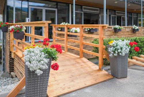 two vases filled with flowers on a wooden deck at Club Hotel am Kreischberg in Sankt Georgen ob Murau
