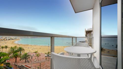 a balcony with a table and a view of a beach at Hotel Aloe Canteras in Las Palmas de Gran Canaria