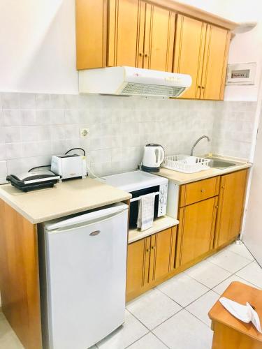 a small kitchen with wooden cabinets and white appliances at Banos Apartments and Swimming Pool STUDIO in Roda