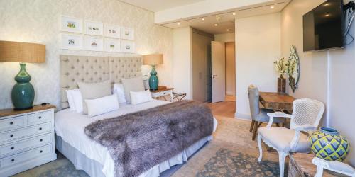 a bedroom with a bed and a desk and a television at One Bedroom Apartment - fully equipped Waterfront based in Cape Town