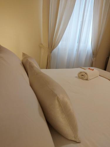 a white bed with a pillow and a towel on it at Cà Sottomarina gli Appartamenti in Centro Apartsuite in Sottomarina