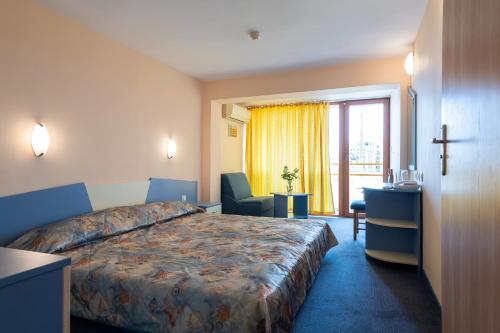 a hotel room with a bed and a cross on the wall at Nessebar Beach Hotel in Sunny Beach