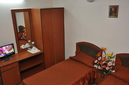 a bedroom with a bed and a desk with a mirror at hotelpearlinn in Bengaluru