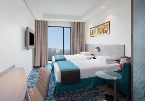 a hotel room with two beds and a tv at Holiday Inn Express Kolkata Airport by IHG in Kolkata