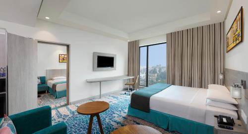 a hotel room with a bed and a desk at Holiday Inn Express Kolkata Airport, an IHG Hotel in Kolkata