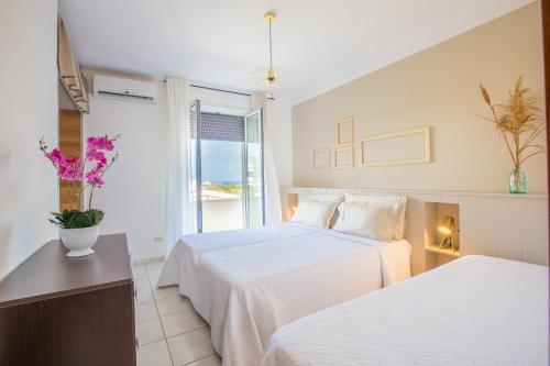 a hotel room with two beds and a window at Villa Salento in Torre Santa Sabina