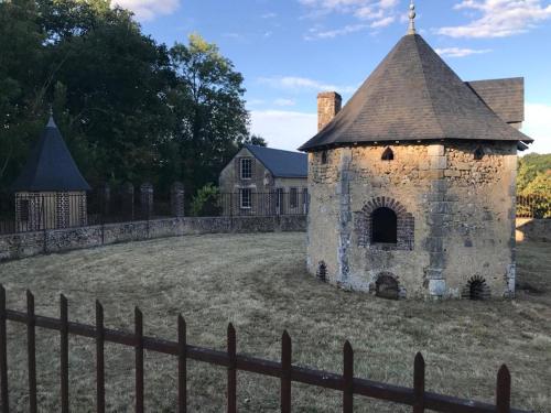 an old building in a field next to a fence at Domaine de la Vaudouriere in Lunay