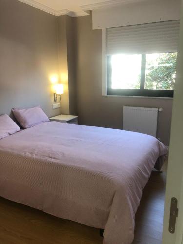 - une chambre avec un grand lit blanc et une fenêtre dans l'établissement ESTUDIO Zona Norte Santiago de Compostela VUTCO-04046, à Saint-Jacques-de-Compostelle