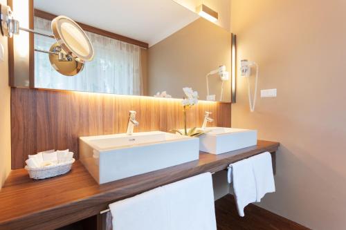 ein Bad mit einem Waschbecken und einem Spiegel in der Unterkunft Hotel Marolt Dependance in Sankt Kanzian am Klopeiner See
