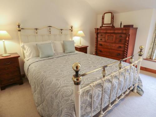 a bedroom with a bed and a dresser at Croft Cottage in Matlock
