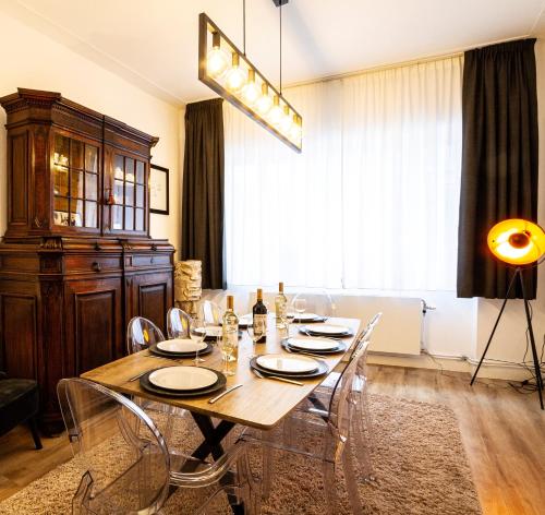 una sala da pranzo con tavolo e sedie in legno di La Maison Bleue - Wellness - SPA a Spa