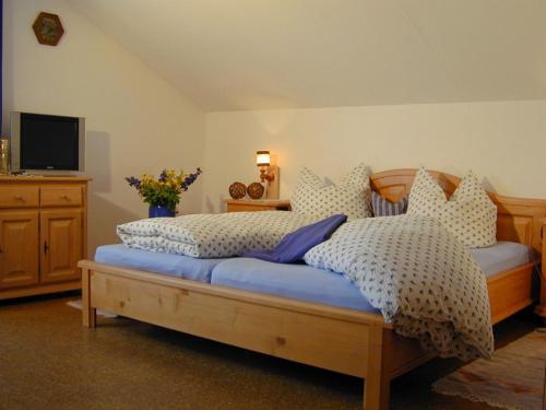 Schlafzimmer mit einem Bett mit Kissen und einem TV in der Unterkunft Kochhof in Piding