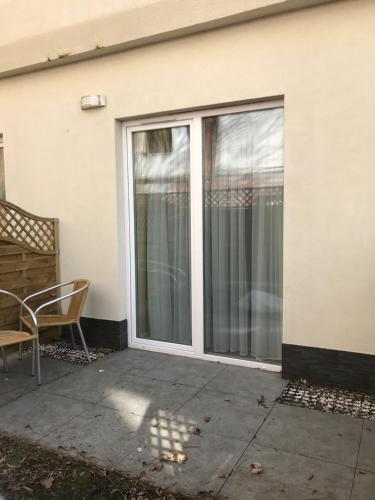 a sliding glass door of a house with a chair at Lazur Apartamenty in Świnoujście