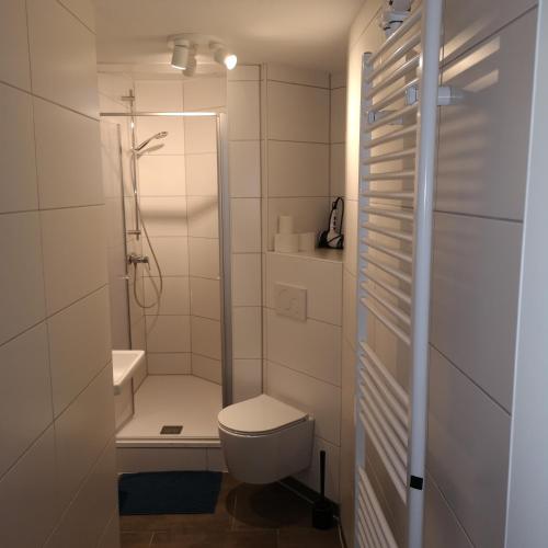 een witte badkamer met een toilet en een douche bij Hafenstraße 98 - Apartment im 4. Obergeschoss in Bremerhaven