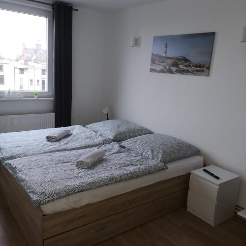ein Schlafzimmer mit einem Bett und einem Telefon darauf in der Unterkunft Hafenstraße 98 - Apartment im 4. Obergeschoss in Bremerhaven