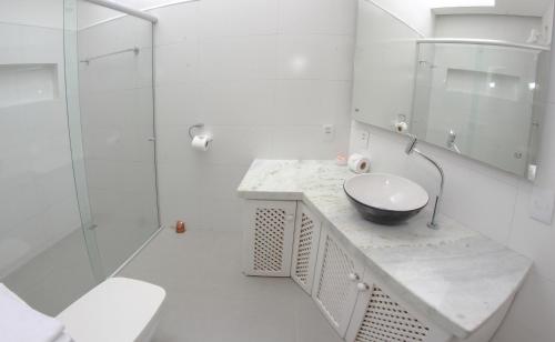 Un baño blanco con lavabo y ducha. en Azul Pousada, en Jericoacoara
