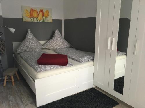 ブラウンラーゲにあるApartments Gosch Braunlageの赤い袋が付いた小さな部屋のベッド1台分です。